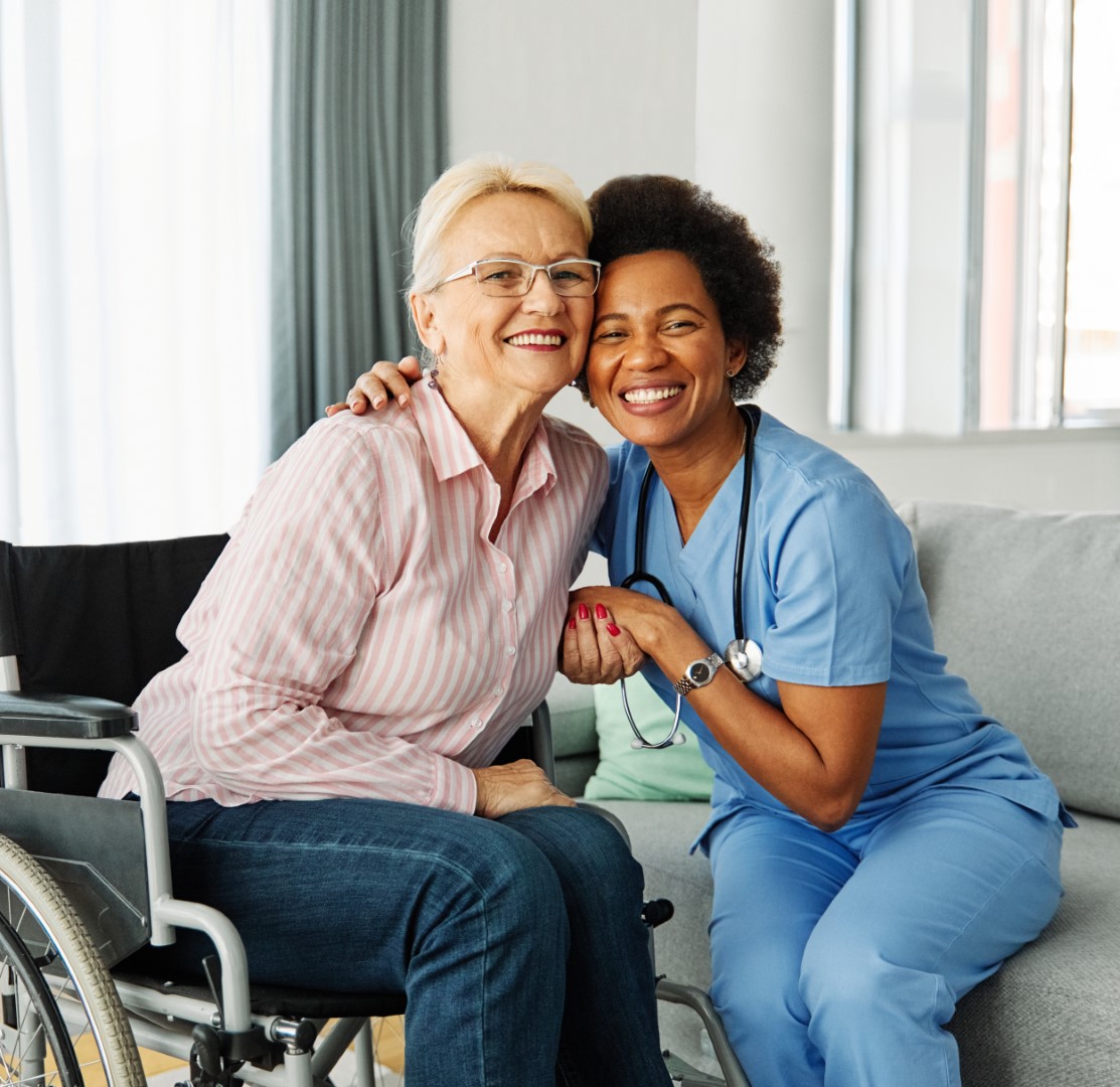 Doctor or nurse caregiver helping  senior woman in a wheelchair at home or nursing home