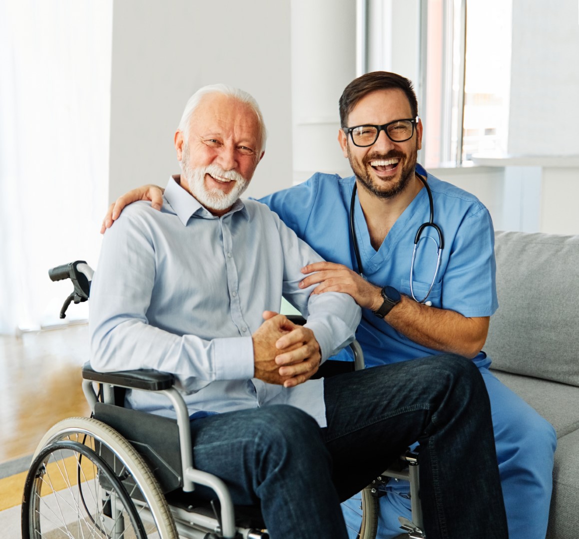 Doctor or nurse caregiver helping  senior man in a wheelchair at home or nursing home
